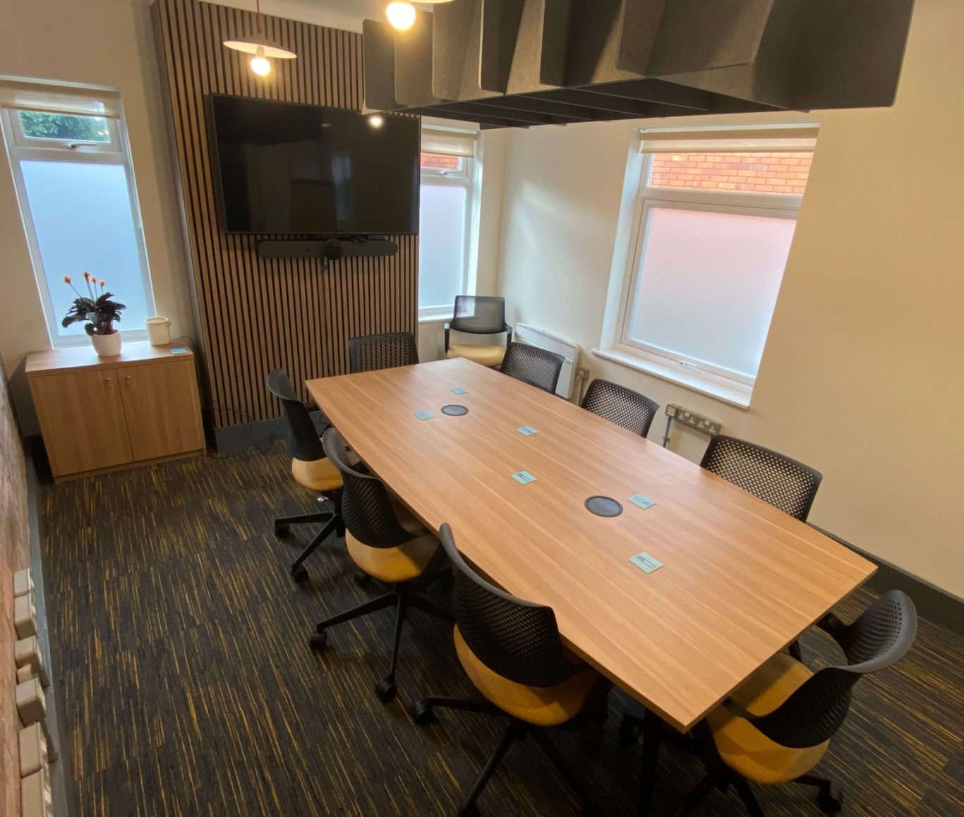 Modern meeting room with a large boardroom table with 8 seats around it